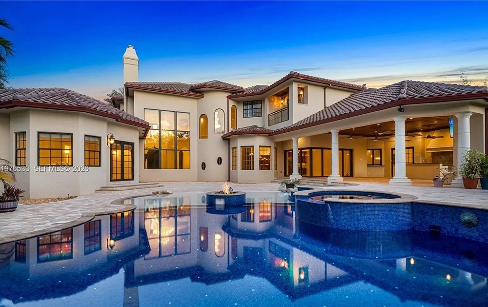 Luxury Florida waterfront estate illuminated at twilight with a reflecting pool